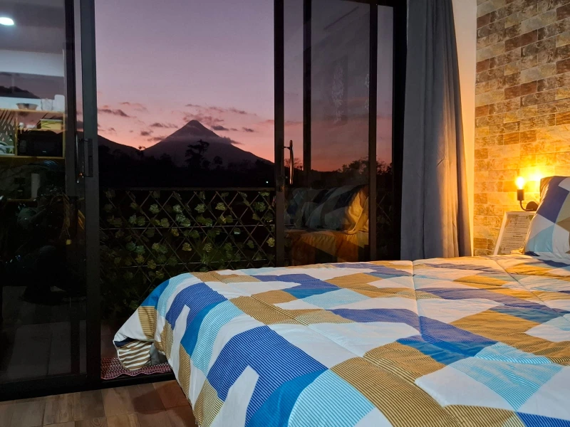 Sunset and Arenal Volcano landscape seen from the room at Arenal Tiny Lodge