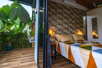 Habitación del Lodge 2 con acceso a terraza y vegetación tropical
