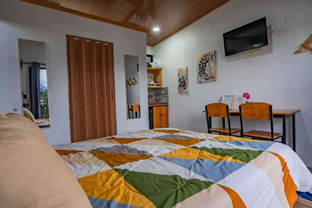 Interior de Arenal Tiny Lodge 1 con cama y comedor